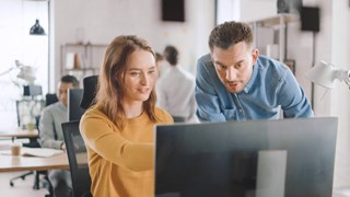 Istock 1261397555 Woman Pointing At Screen Man Looking Blue Filter