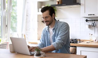 Istock 1279978023 Happy Man In Kitchen W Laptop Blue Filter A